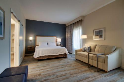 Habitación de hotel con cama y sofá en Hampton Inn Sneads Ferry Topsail Beach en Sneads Ferry