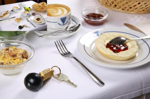 a table topped with plates of food and a cup of coffee at Hotel Post Gries in Bolzano