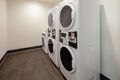 three washing machines are in a laundry room at Home2 Suites By Hilton Alameda Oakland Airport in Alameda
