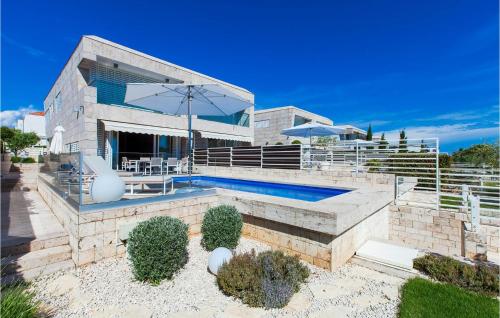 a house with a swimming pool and an umbrella at Villa Olea in Petrcane