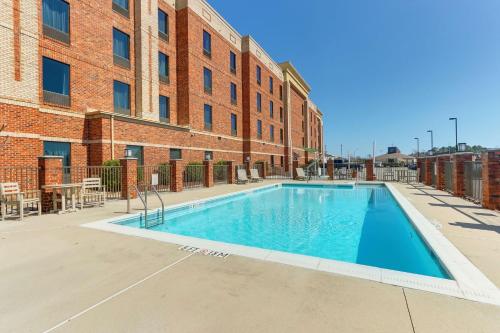 einem Pool vor einem Backsteingebäude in der Unterkunft Hampton Inn and Suites Swansboro Near Camp Lejeune in Swansboro