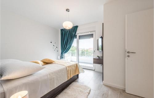 a white bedroom with a bed and a window at Villa Oasis in Sukošan