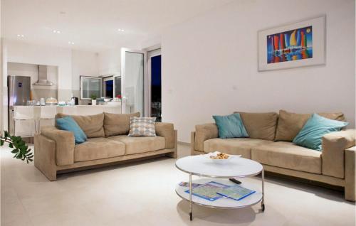 a living room with two couches and a table at Villa Crystal Blue in Rogoznica