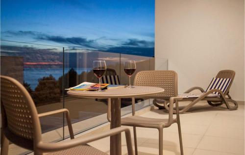 a table with two glasses of wine on a balcony at Villa Crystal Blue in Rogoznica