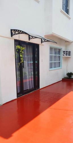 una puerta abierta de un edificio con suelo rojo en Santa Cruz Garden, en Tacloban