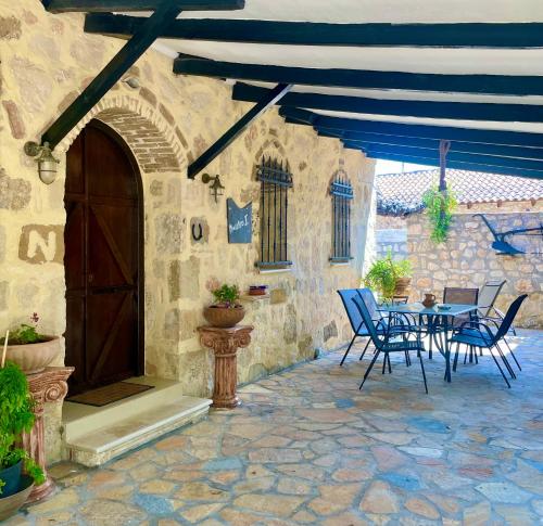 a patio with a table and chairs in a building at Windy Inns ( Maistros I ) in Vouyiáton