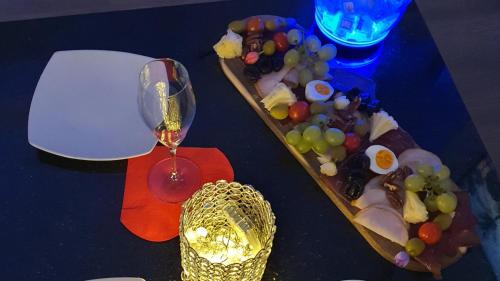 a table with a glass of wine and a bunch of grapes at Privat-Spa mit Whirlpool und Sauna in Sursee in Sursee