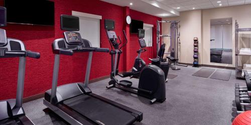 a gym with cardio equipment and a red wall at Home2 Suites by Hilton Ocean City Bayside in Ocean City
