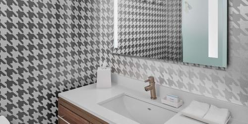 a bathroom with a sink and a mirror at Home2 Suites by Hilton Ocean City Bayside in Ocean City