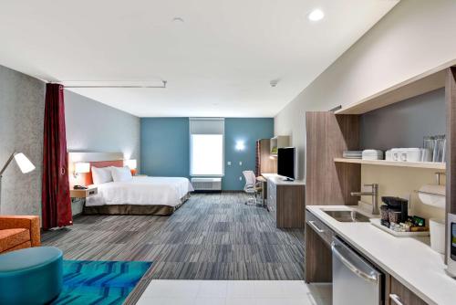 a hotel room with a bed and a kitchen at Home2 Suites by Hilton OKC Midwest City Tinker AFB in Midwest City