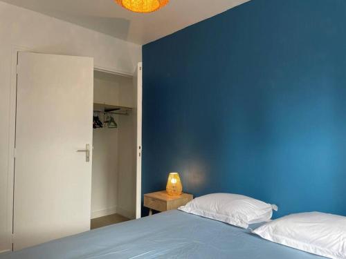 - une chambre bleue avec un lit et un mur bleu dans l'établissement Maison Familiale idéale pour les Vacances/Weekends, à Dinard