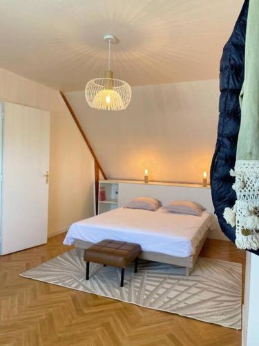 une chambre avec un lit et un lustre dans l'établissement Maison Familiale idéale pour les Vacances/Weekends, à Dinard