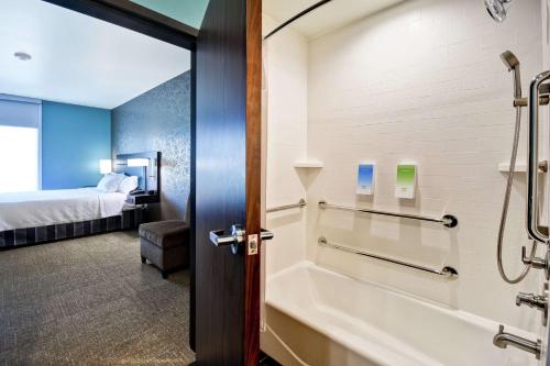 a bathroom with a bath tub and a bed at Home2 Suites By Hilton El Reno in El Reno