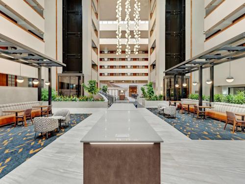 an empty lobby of a hotel with tables and chairs at Embassy Suites by Hilton Oklahoma City Will Rogers Airport in Oklahoma City