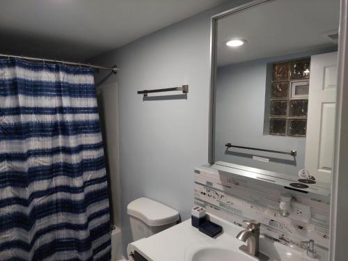 uma casa de banho com um lavatório, um espelho e um WC. em Casa Cerca De La Playa em Chicago