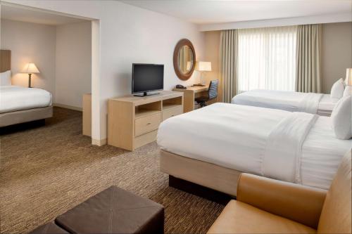 um quarto de hotel com duas camas e uma televisão em DoubleTree by Hilton Olympia em Olympia