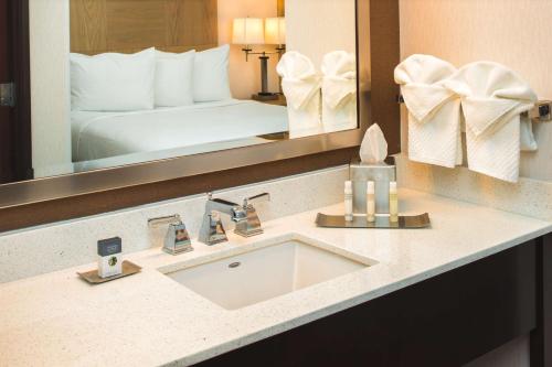 a bathroom with a sink and a large mirror at DoubleTree by Hilton Olympia in Olympia