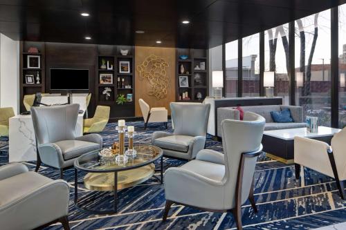 a lobby with chairs and a table and a tv at Embassy Suites By Hilton Oklahoma City Northwest in Oklahoma City