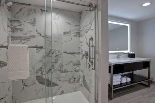 a bathroom with a shower and a sink at Embassy Suites By Hilton Oklahoma City Northwest in Oklahoma City