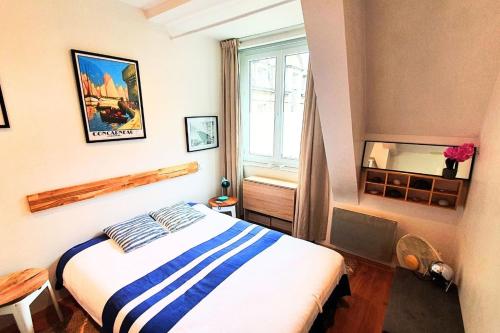 um pequeno quarto com uma cama e uma janela em Haven of peace near the beaches in Saint-Malo em Saint Malo