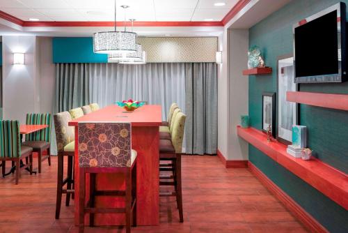 a waiting room with a table and chairs and a tv at Hampton Inn Bellevue in Bellevue