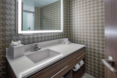 y baño con lavabo y espejo. en Home2 Suites by Hilton Omaha I-80 at 72nd Street, NE en Omaha