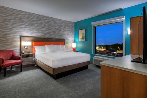 a hotel room with a bed and a large window at Home2 Suites by Hilton Omaha I-80 at 72nd Street, NE in Omaha