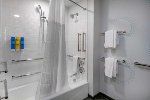 uma casa de banho branca com um chuveiro e uma banheira em Tru By Hilton Omaha I 80 At 72Nd Street, Ne em Omaha