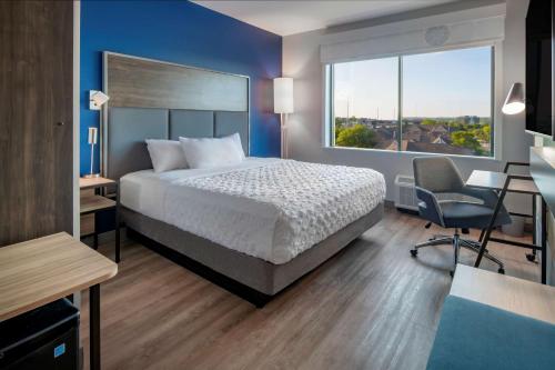 a bedroom with a bed and a desk and a window at Tru By Hilton Omaha I 80 At 72Nd Street, Ne in Omaha