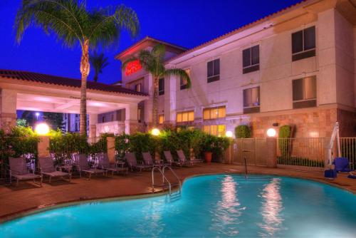 a pool in front of a hotel at night at Hampton Inn & Suites Ontario in Ontario