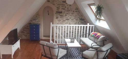 un salon avec deux chaises et une table dans l'établissement La Glycine, à Landévant