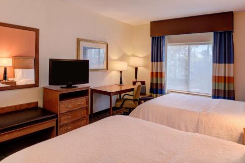 a hotel room with two beds and a flat screen tv at Hampton Inn & Suites Ontario in Ontario