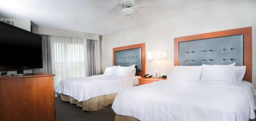 een hotelkamer met 2 bedden en een flatscreen-tv bij Homewood Suites by Hilton Ontario Rancho Cucamonga in Rancho Cucamonga