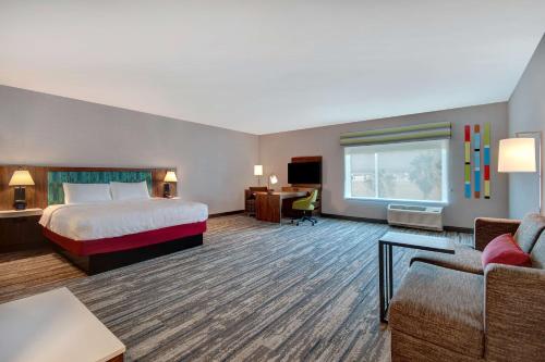 ランチョ・クカモンガにあるHampton Inn & Suites By Hilton Rancho Cucamongaのベッドとデスクが備わる広い客室です。