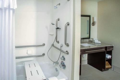 a bathroom with a tub and a shower and a sink at Homewood Suites by Hilton Munster in Munster
