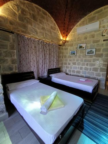 a room with two beds with a napkin on them at palm shadow resort in Tunis