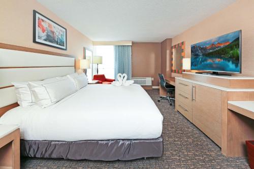 um quarto de hotel com uma cama grande e uma televisão em DoubleTree by Hilton Virginia Beach em Virginia Beach