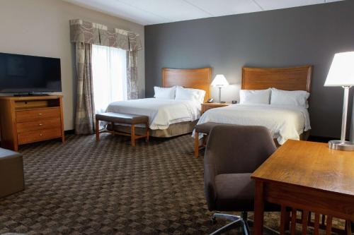 a hotel room with two beds and a flat screen tv at Hampton Inn & Suites Chesapeake-Square Mall in Chesapeake