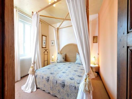 a bedroom with a canopy bed and a window at Maison des Anges in Bouin