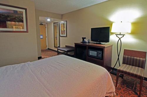 a hotel room with a bed and a flat screen tv at Hampton Inn Norfolk/Chesapeake - Greenbrier Area in Chesapeake