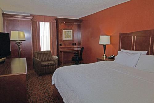 a hotel room with a bed and a chair at Hampton Inn Norfolk/Chesapeake - Greenbrier Area in Chesapeake