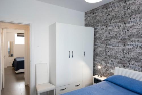 een slaapkamer met een bed en een bakstenen muur bij Casa Mirea di Teti con piscina a Macari in Macari