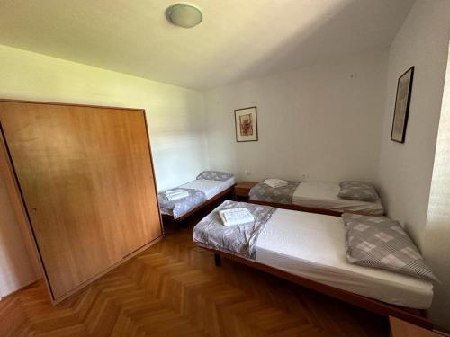 2 camas en una habitación con suelo de madera en Hostel on the road trip, en Materija