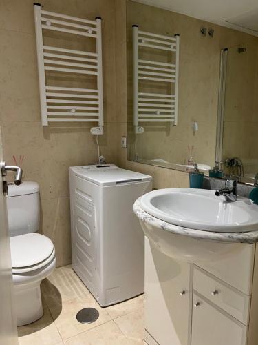 bagno con lavandino, servizi igienici e specchio di Aparment sierra Guadalupe a Madrid