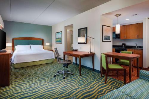 ein Hotelzimmer mit einem Bett, einem Schreibtisch und einer Küche in der Unterkunft Homewood Suites by Hilton Virginia Beach in Virginia Beach