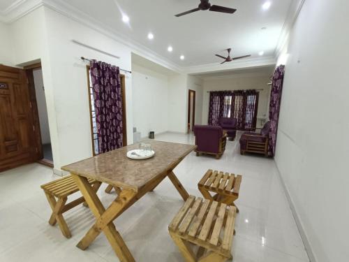 uma sala de jantar com uma mesa de madeira e cadeiras em Hotel BlueSky Ramapuram em Chennai