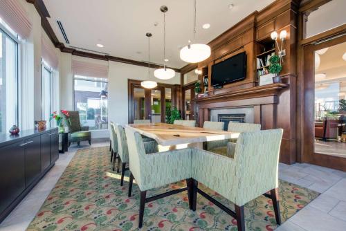 a dining room with a wooden table and chairs at Hilton Garden Inn Devens Common in Devens