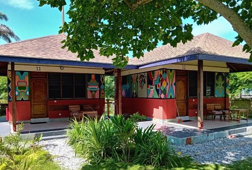 a red house with a painting on it at Ko-Sa Beach Resort Ltd in Ampeni