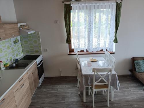 a small kitchen with a table and a sink at Apartmány u Olšinské kapličky in Horní Planá