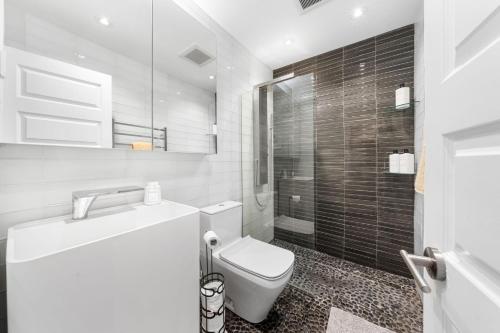 a white bathroom with a toilet and a shower at Waterfront North Wildwood Anglesea Family Retreat in North Wildwood